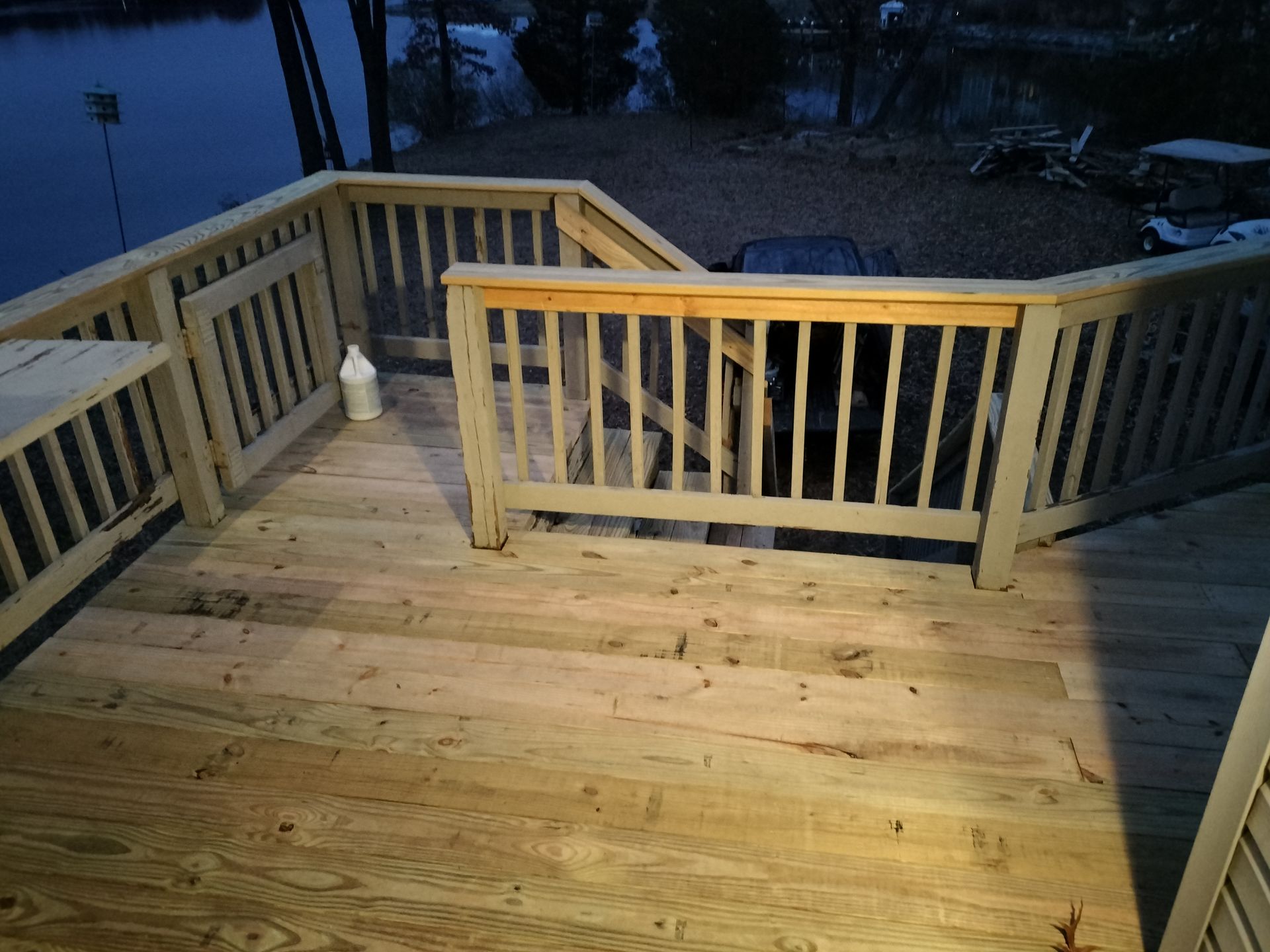 A wooden deck with stairs leading up to it and a railing.