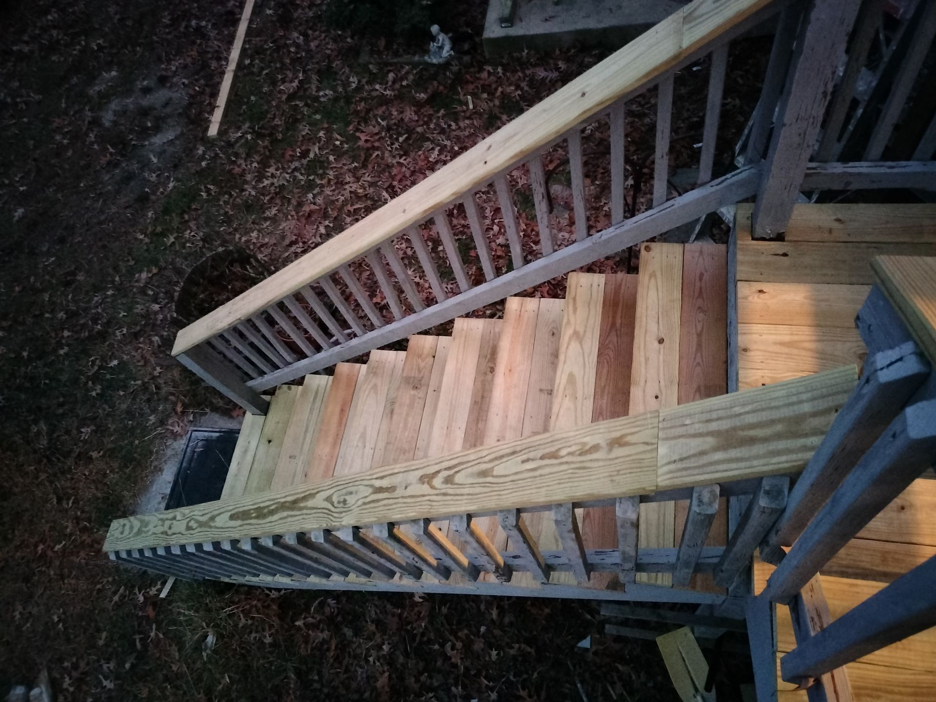 A wooden deck staircase with a metal railing
