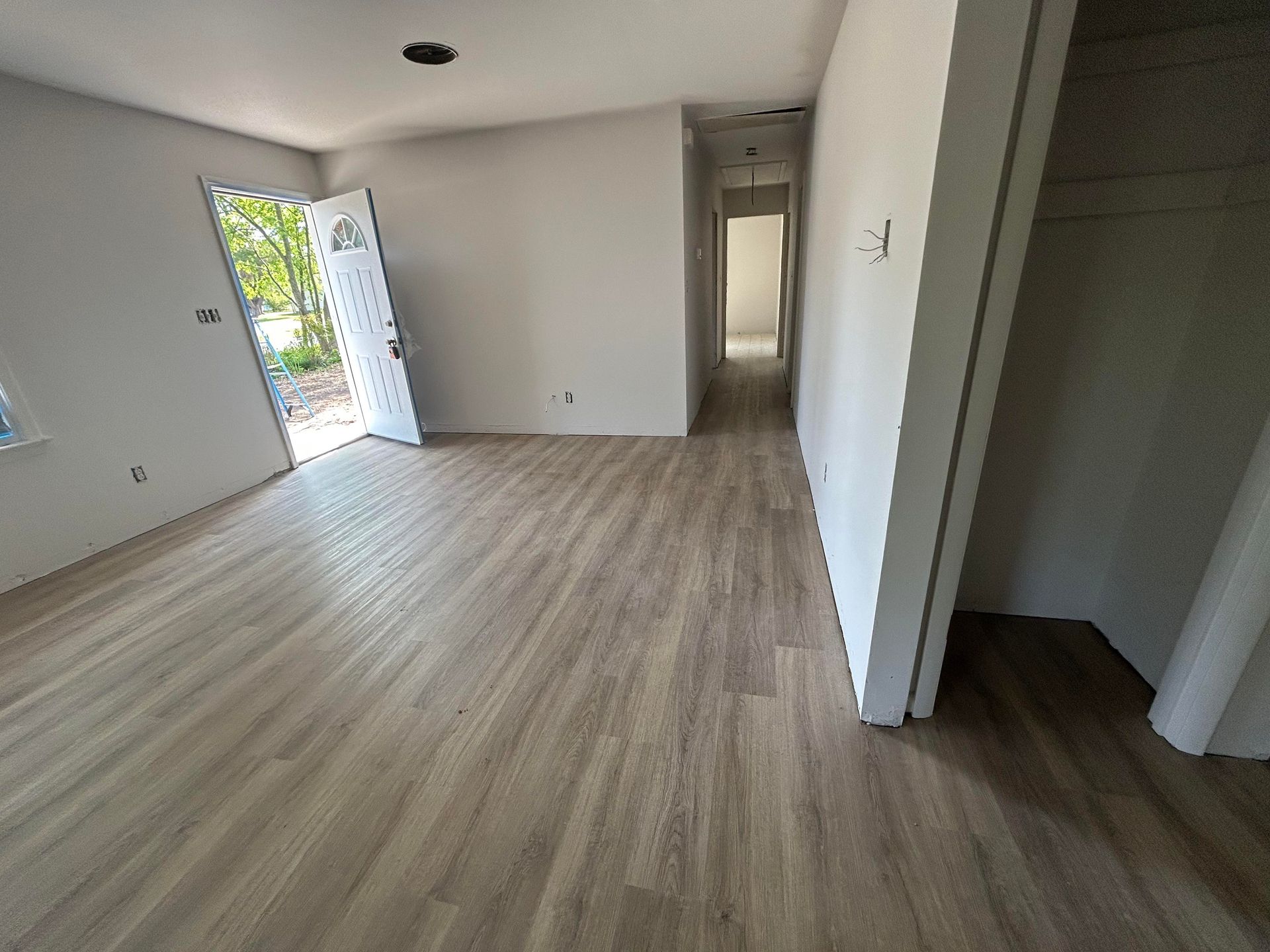 A living room with hardwood floors and white walls.