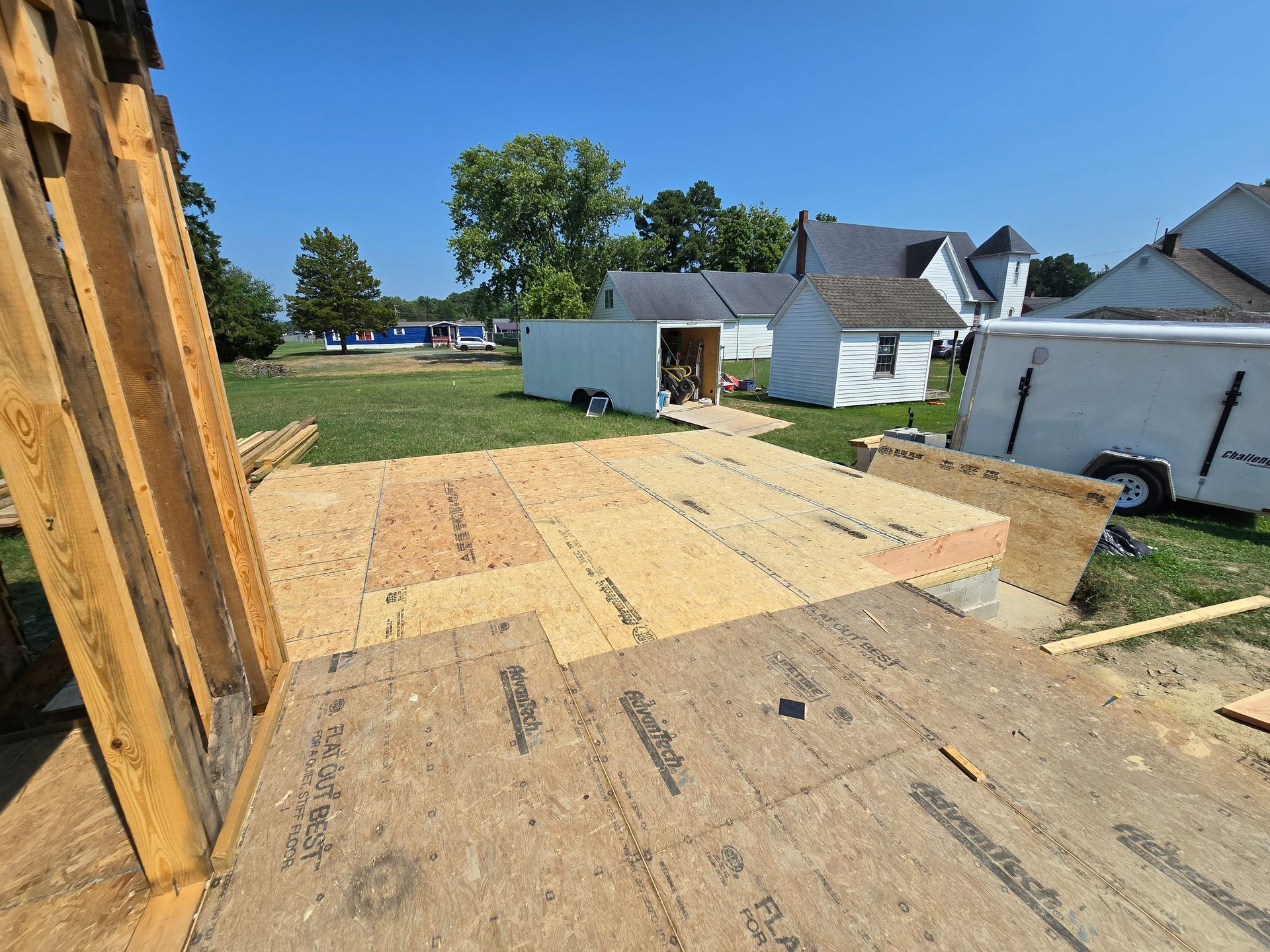 A house is being built on a lush green field.