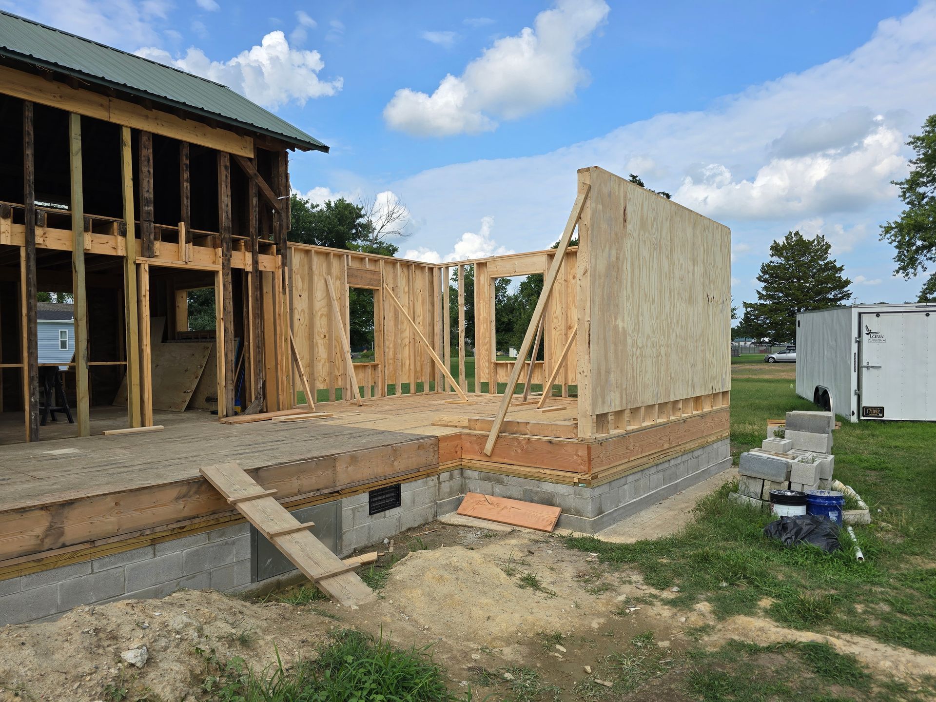 A house is being built on a lush green field.