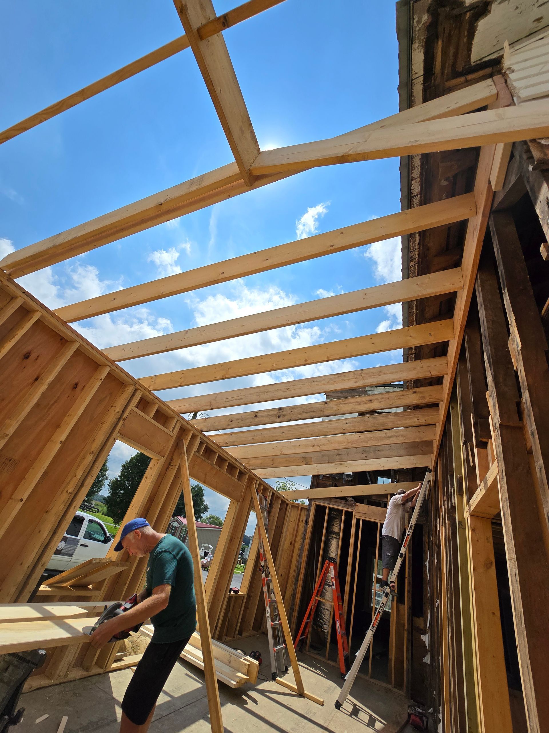 A man is working on the roof of a building under construction.