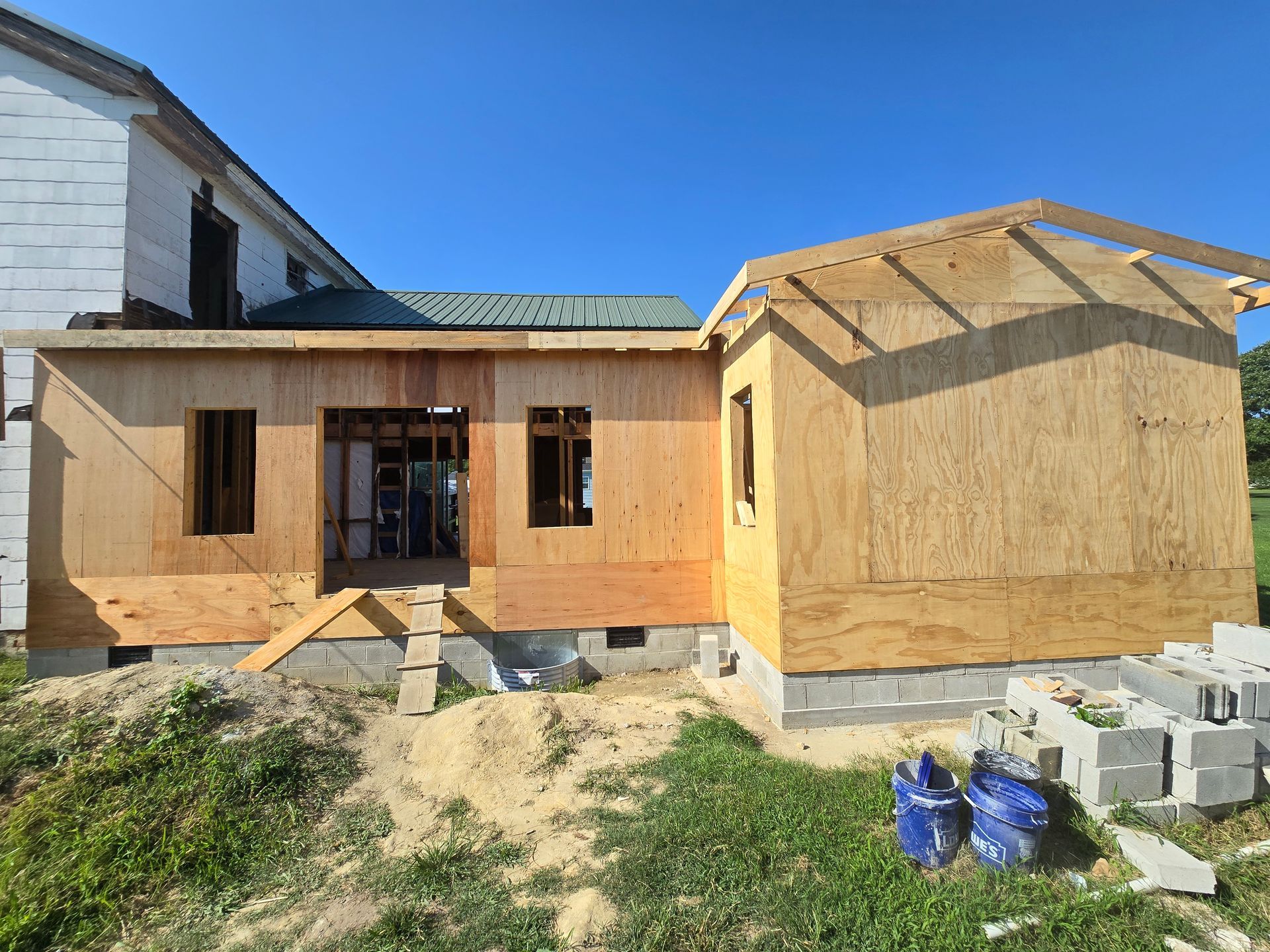 A wooden house is being built in the backyard of a house.