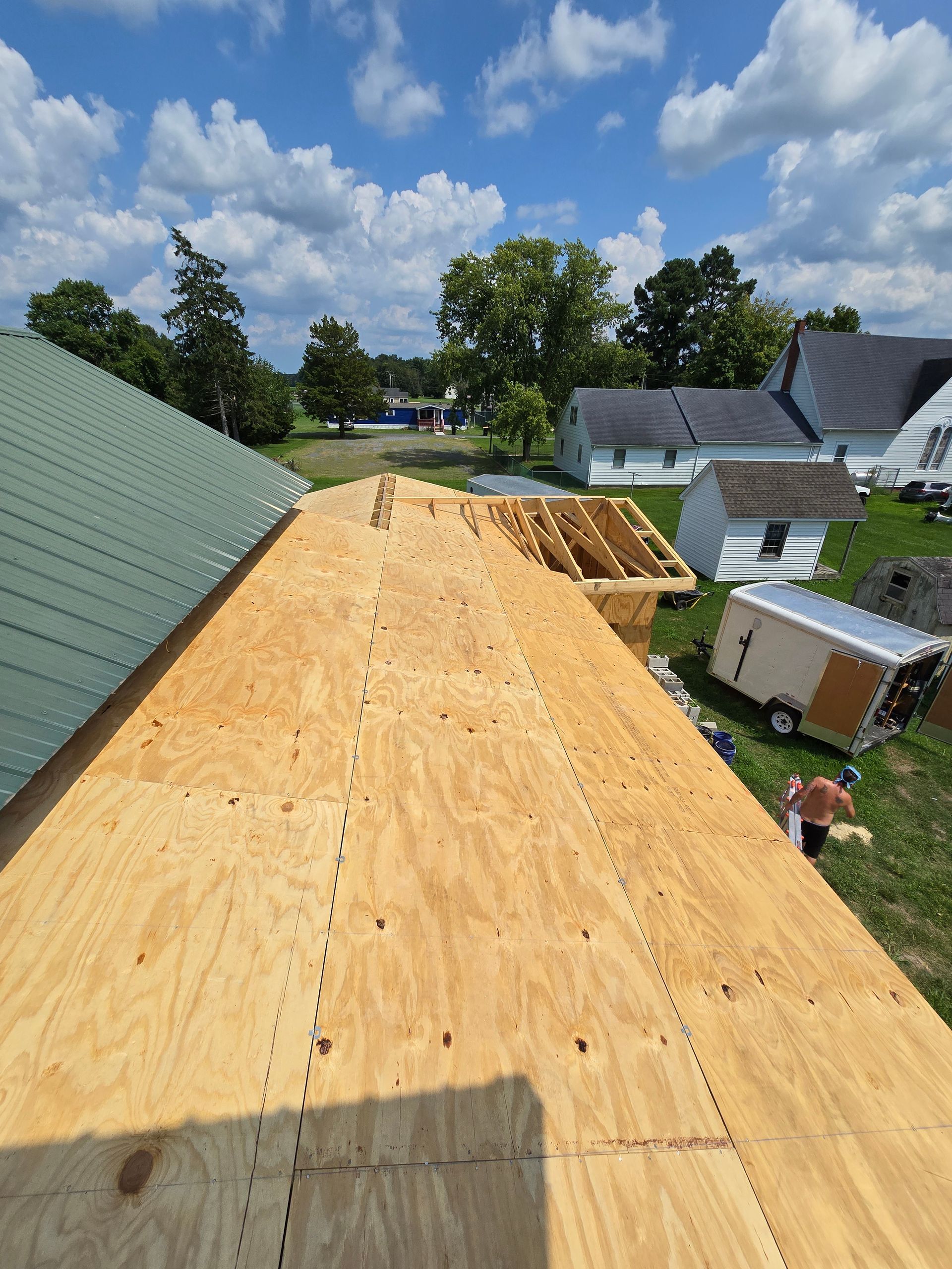 A roof with a lot of plywood on it is being built.