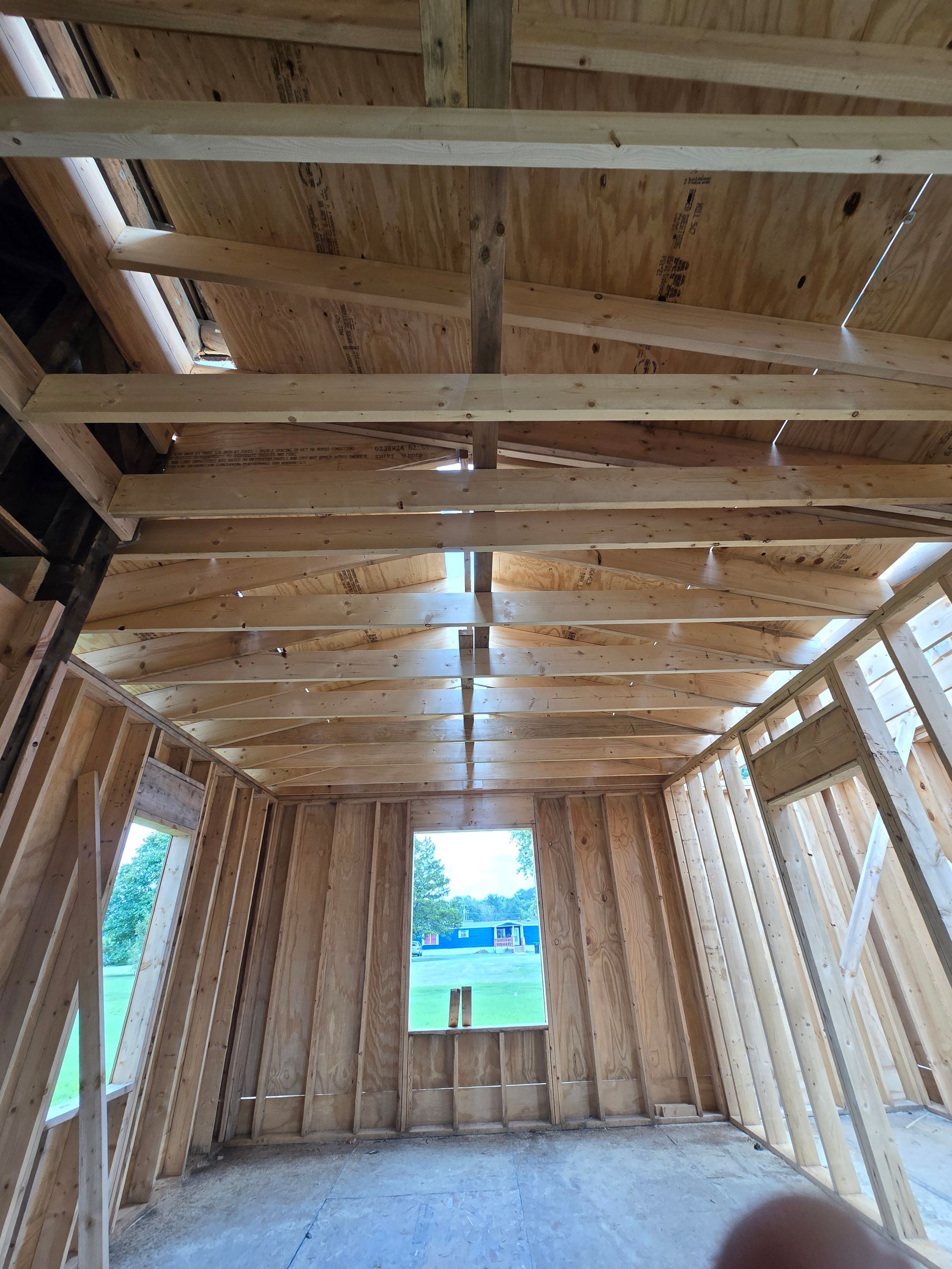 A room under construction with wooden beams and a window.