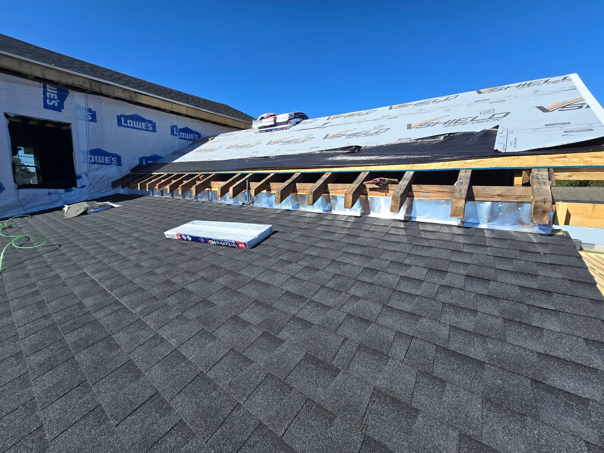 A roof is being installed on a house under construction.