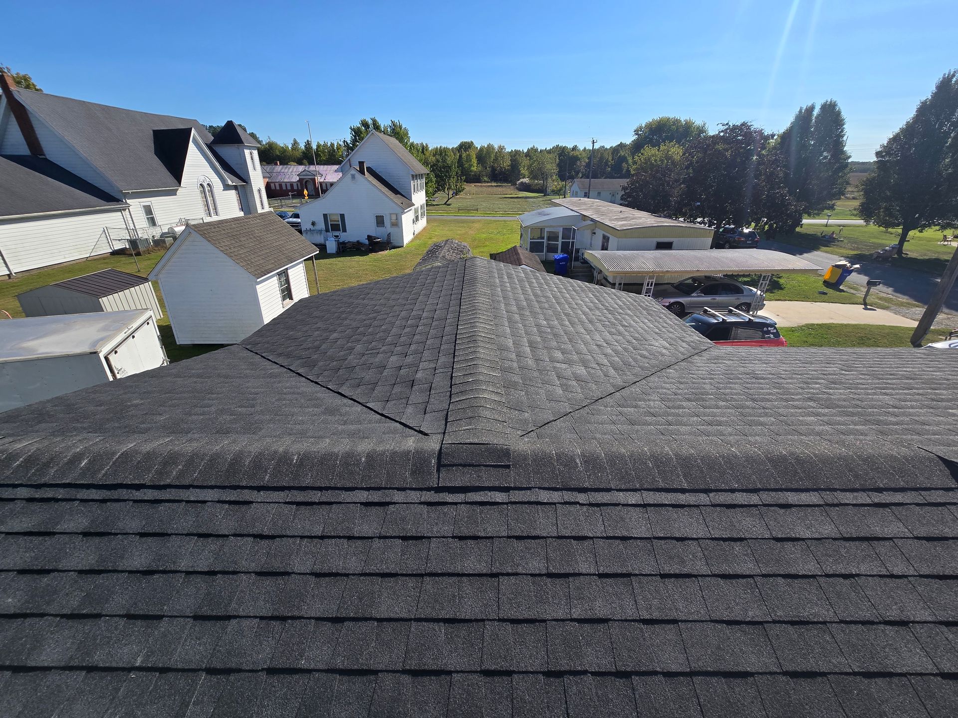 An aerial view of a roof with a lot of houses in the background.