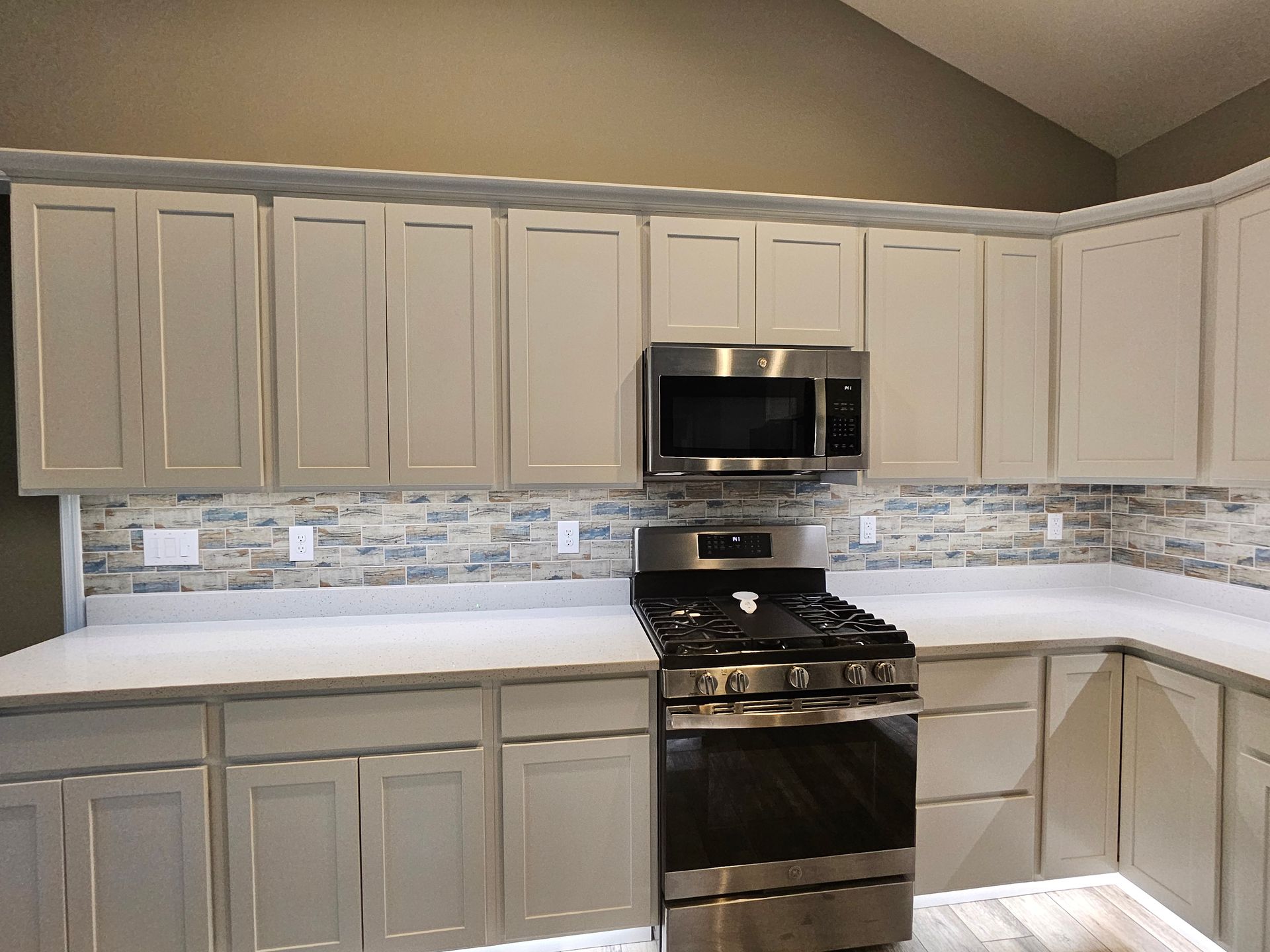 A kitchen with white cabinets and stainless steel appliances