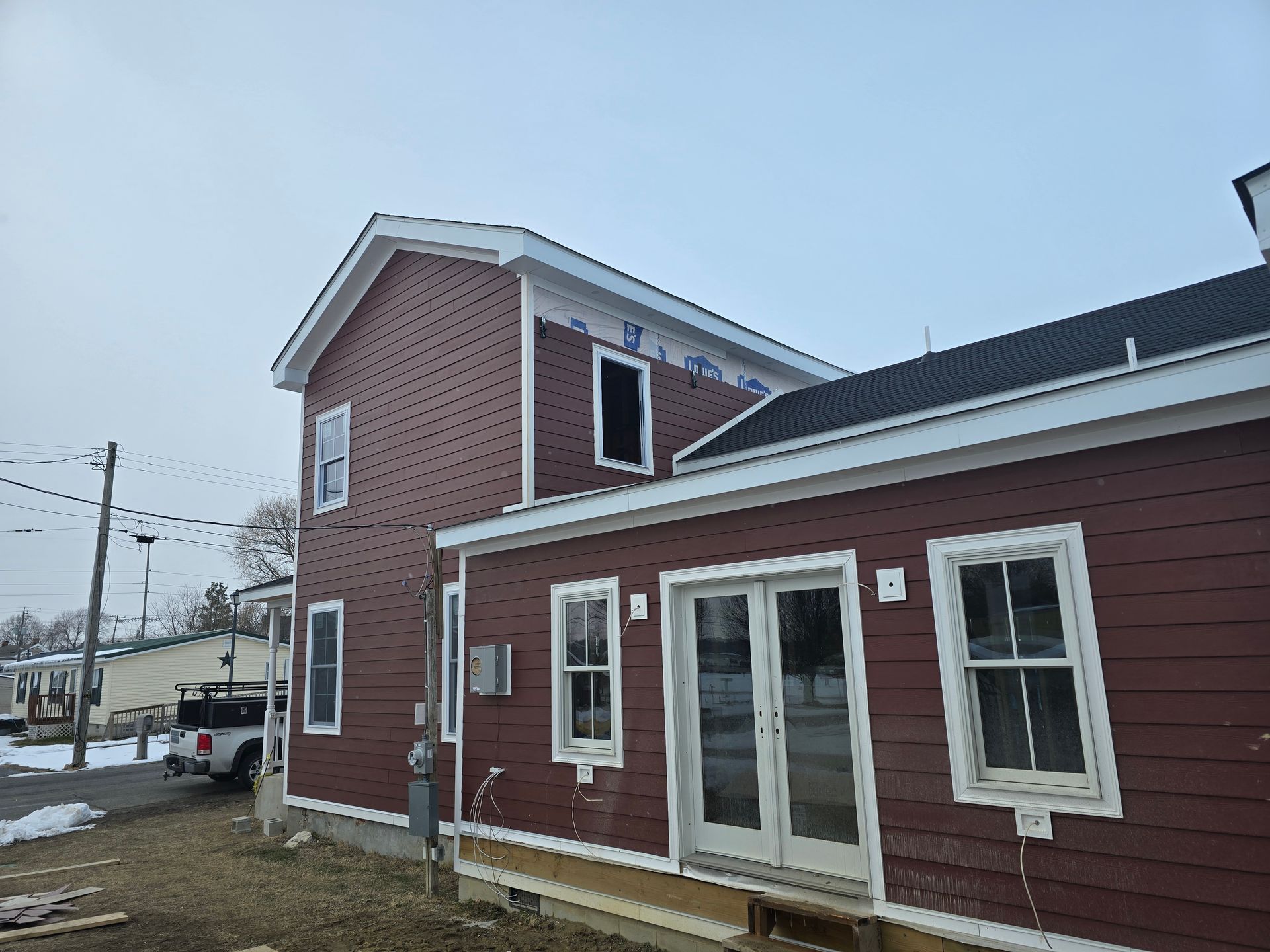A red house with a truck parked in front of it.