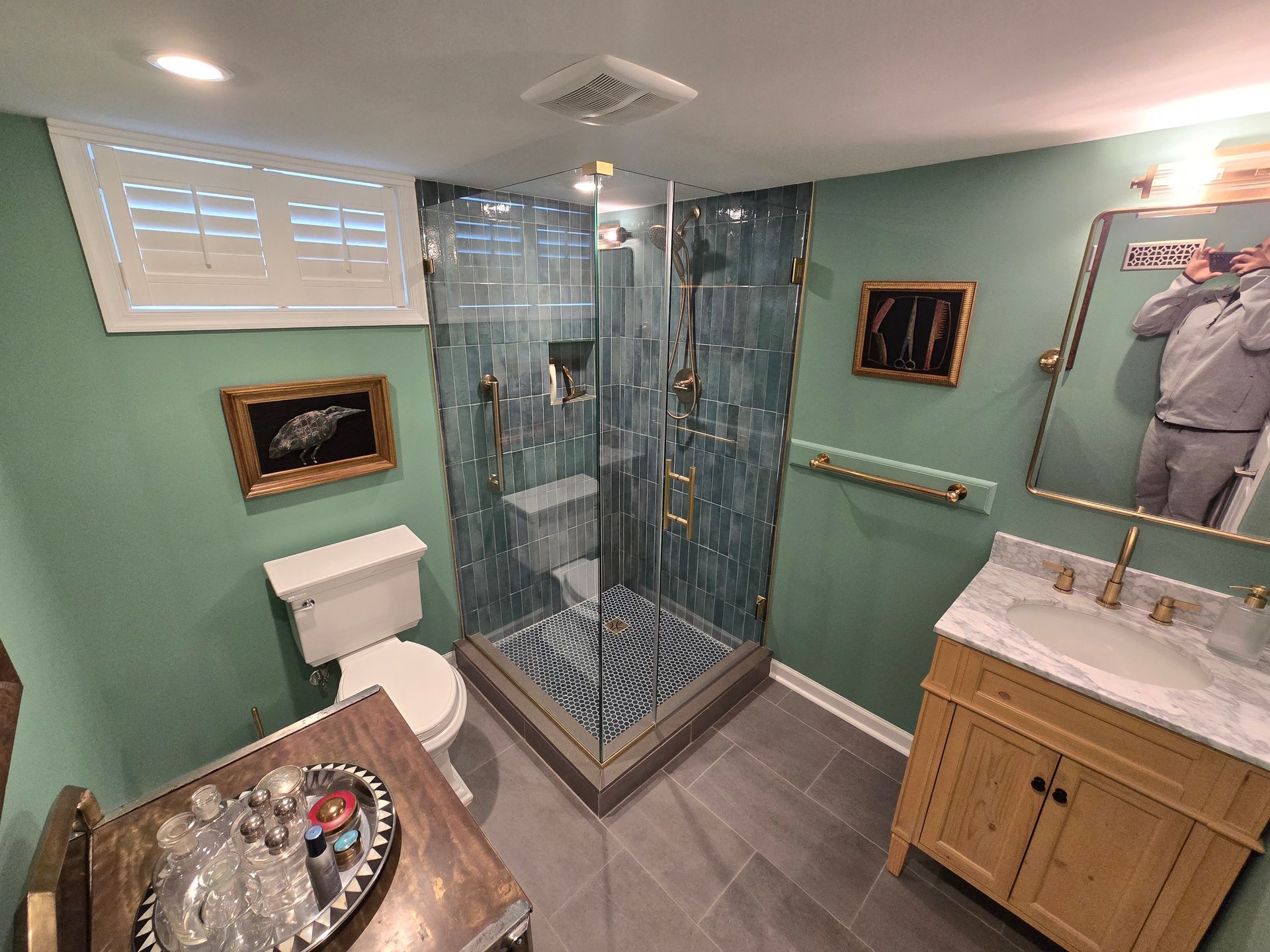 A bathroom with a toilet , sink , shower and mirror.