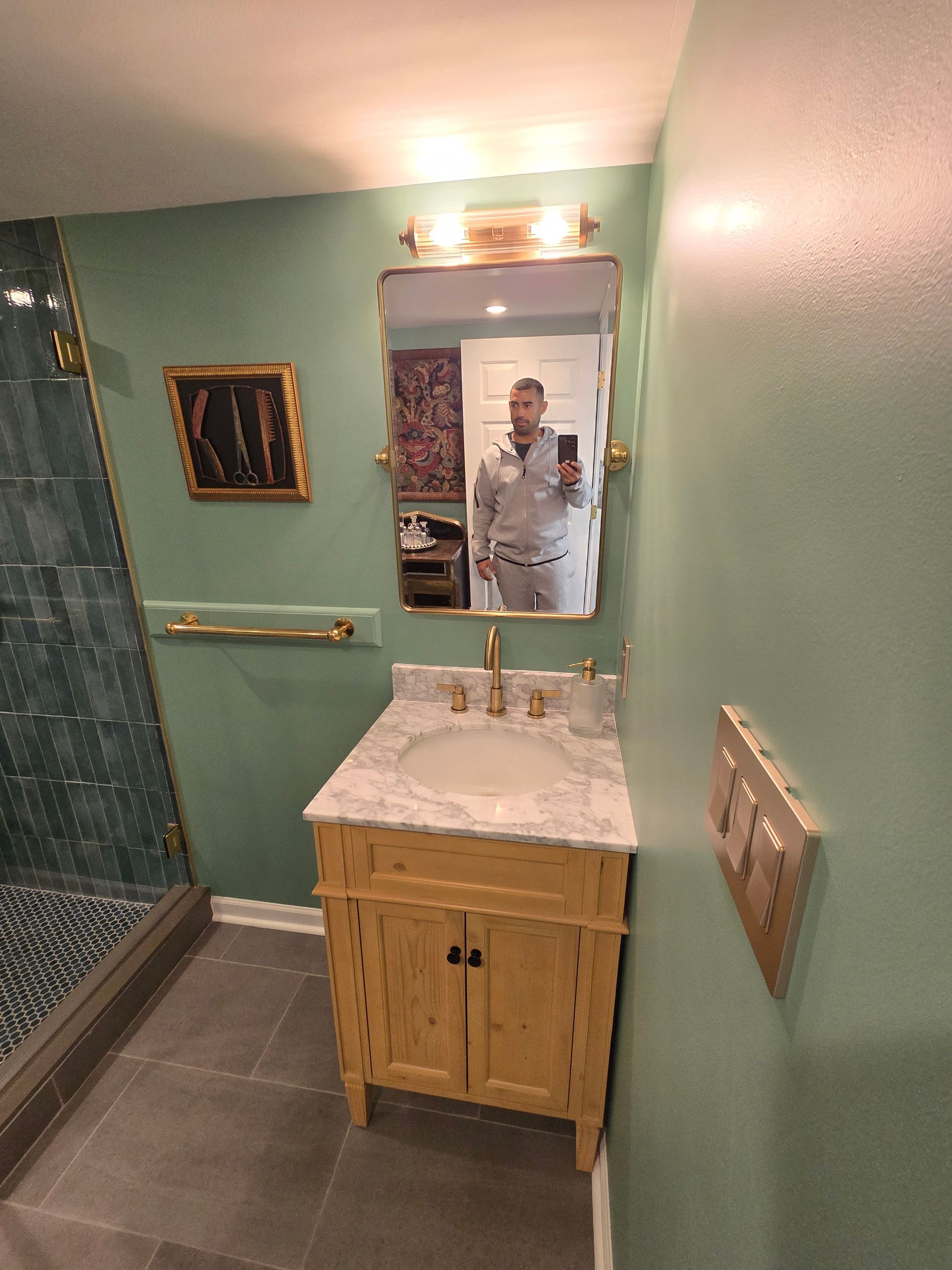 A man is taking a picture of himself in a bathroom mirror.