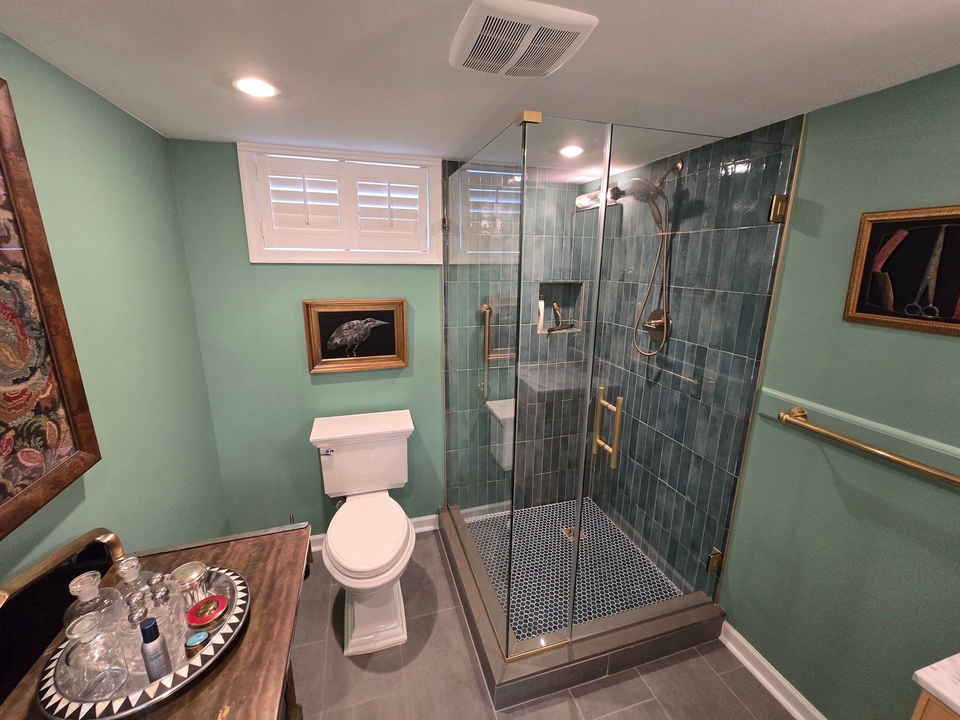 A bathroom with a toilet , sink and walk in shower.