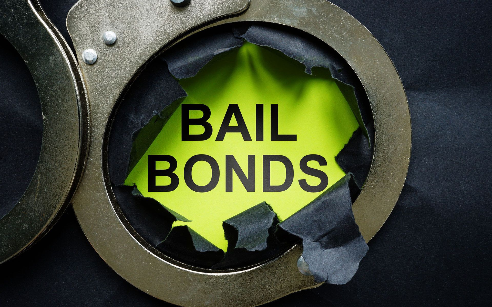 A pair of handcuffs with a yellow sign that says bail bonds