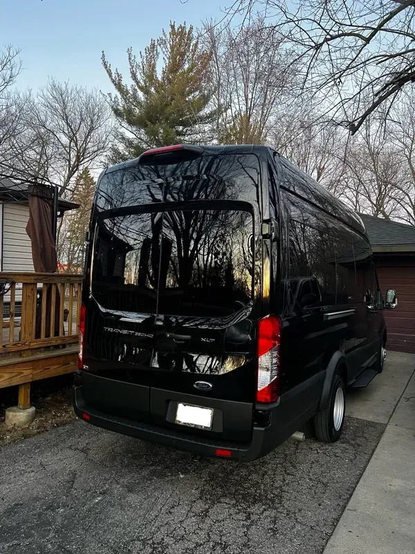 A black van is parked in front of a house