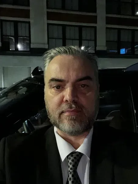 A man with a beard is wearing a suit and tie