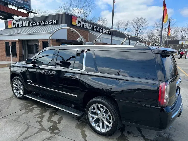 A black suv is parked in front of a car wash.