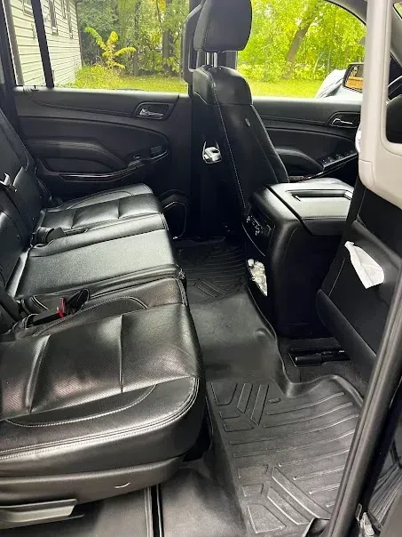 The rear seats of a black suv are empty.