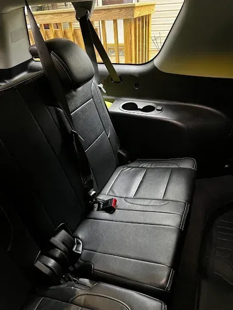 The back seat of a car with a seat belt on it.