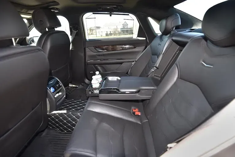 The back seat of a car with a bottle of water in it.