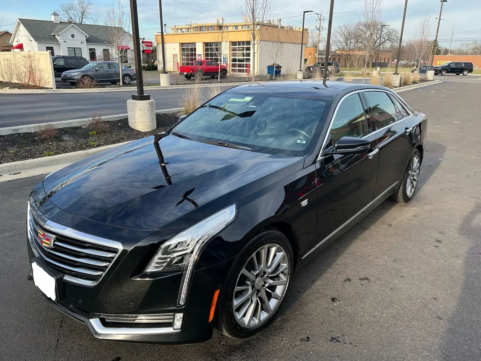 A black cadillac is parked on the side of the road.