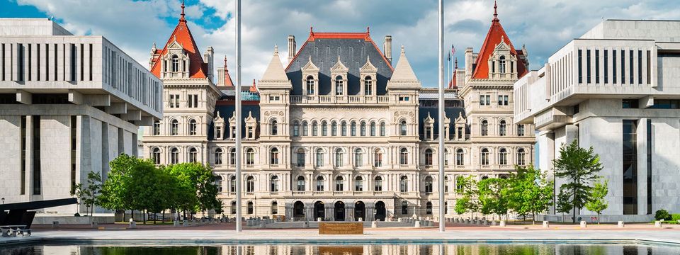 Photo of the New York State Capitol with reflections in a pond. It is the seat of the New York State government, located in downtown Albany, New York, USA.