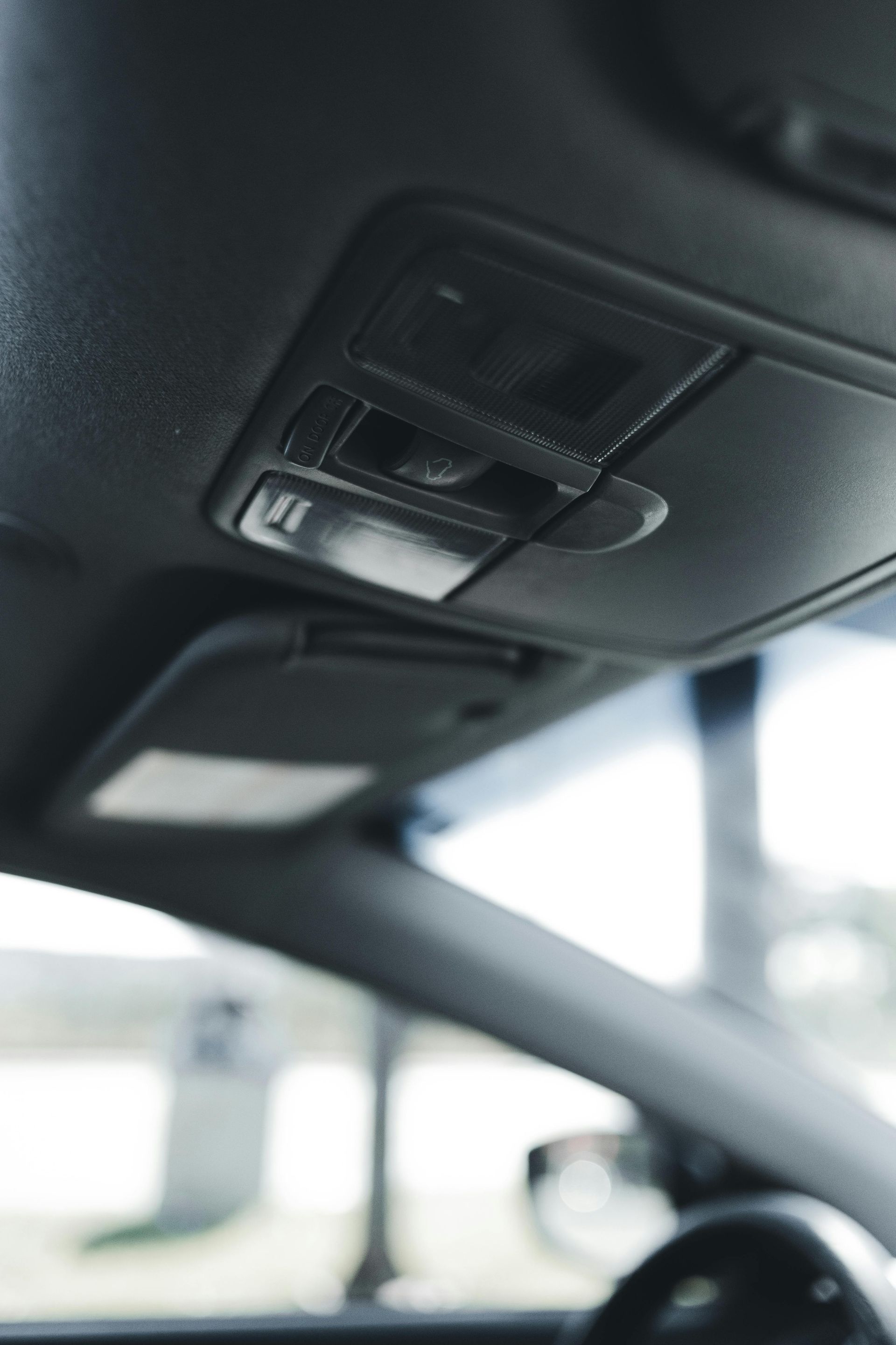 Interior car ceiling with overhead console and sun visor.