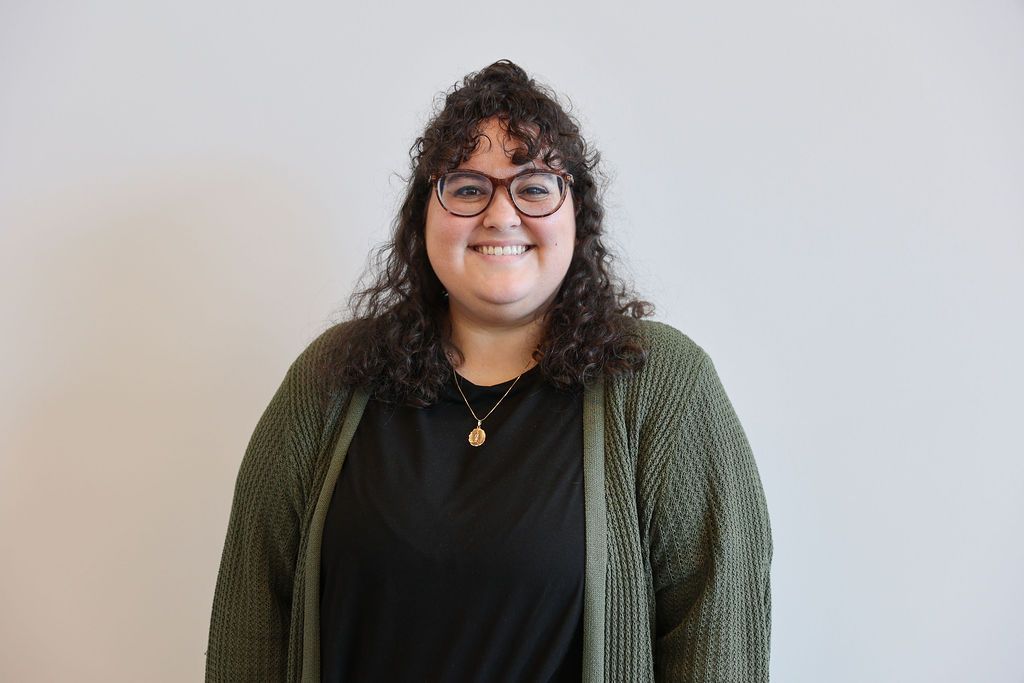 Shadows of horizontal blinds cast across a white wall, creating a striped pattern.