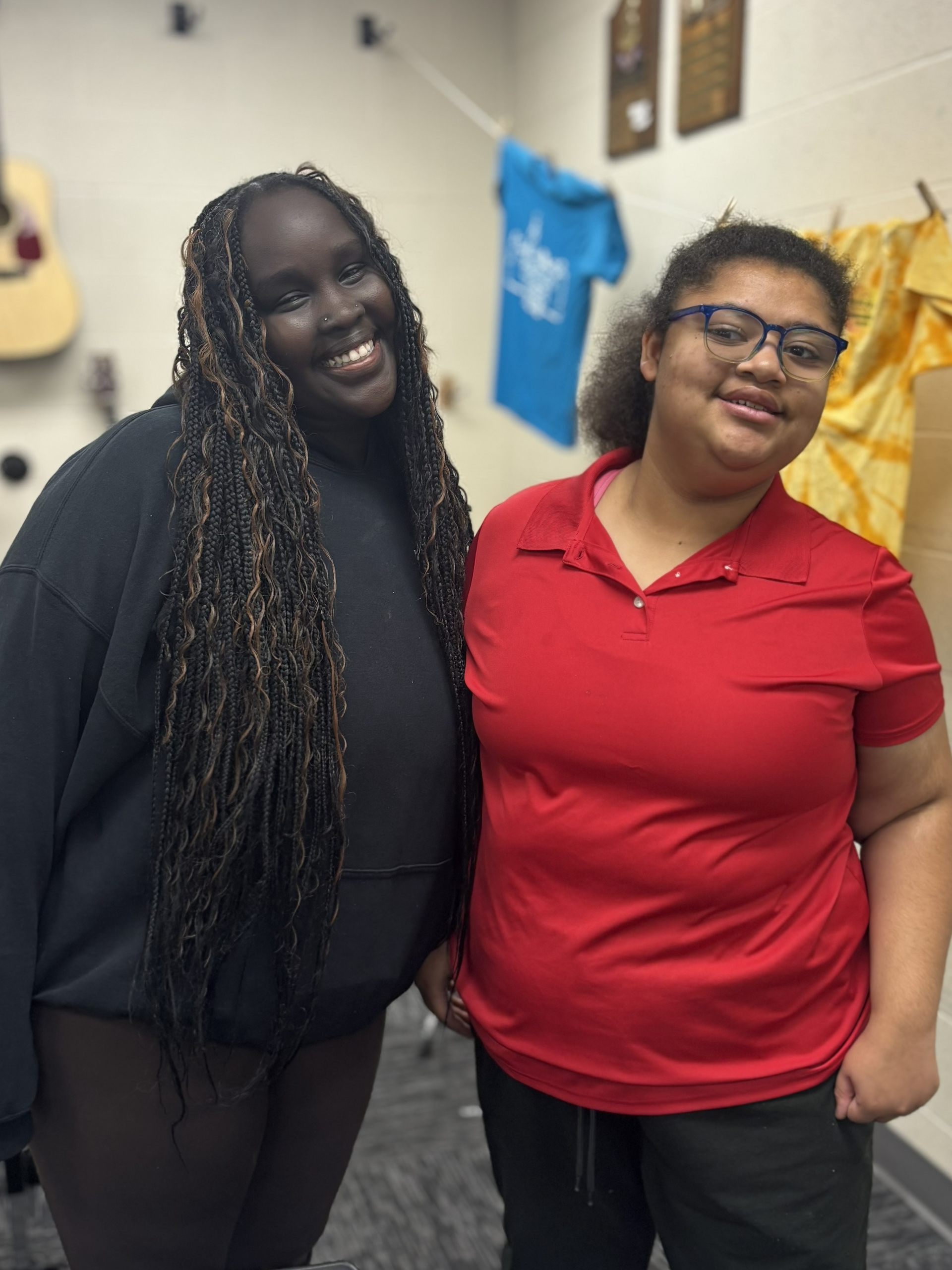 A man in a suit speaks to a group seated around a round table in a classroom.