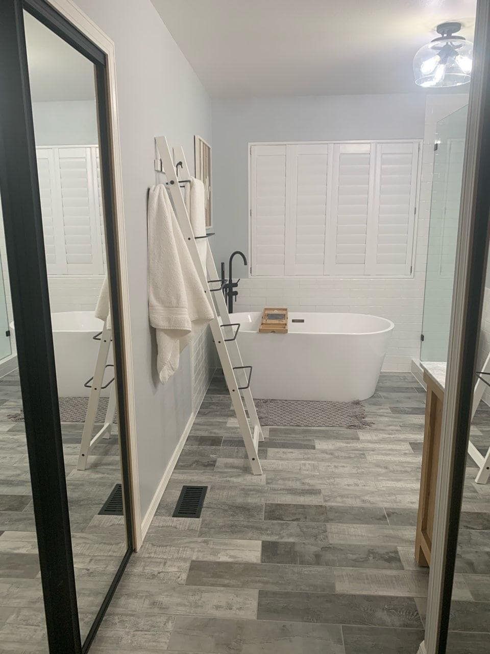 A bathroom with a large mirror and a bathtub.