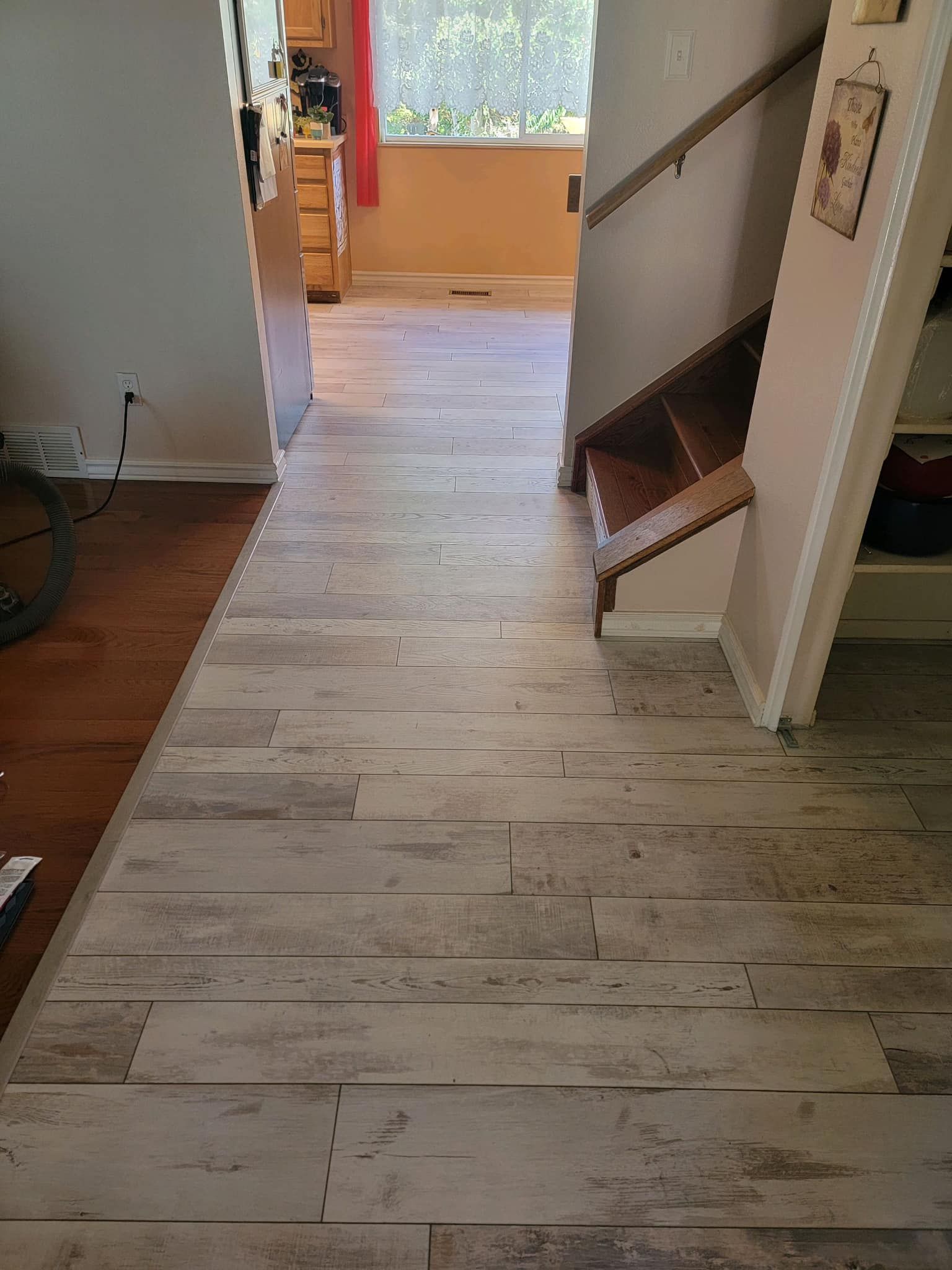 A living room with a wooden floor and stairs leading to the stairs.