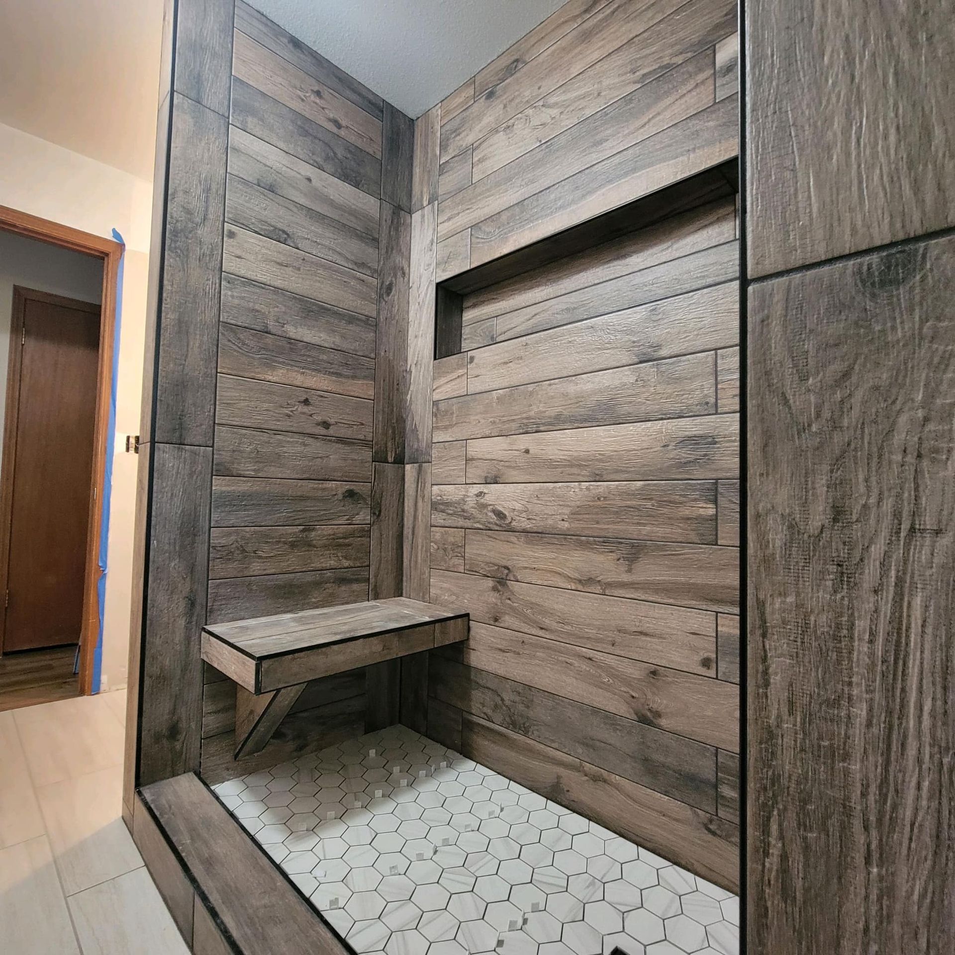 a shower with a brick wall and a soap dispenser in the corner .