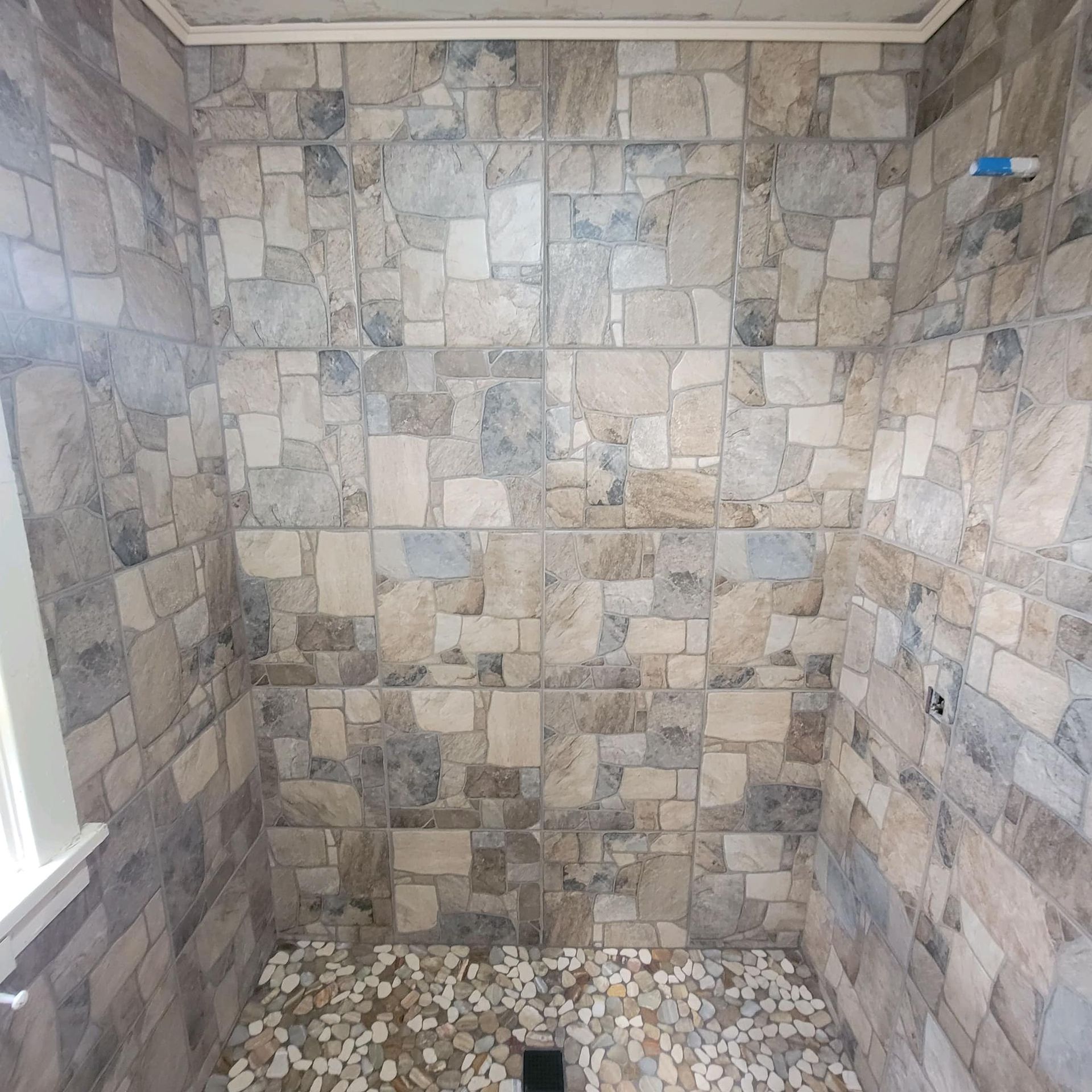 a bathroom with a tiled wall and floor