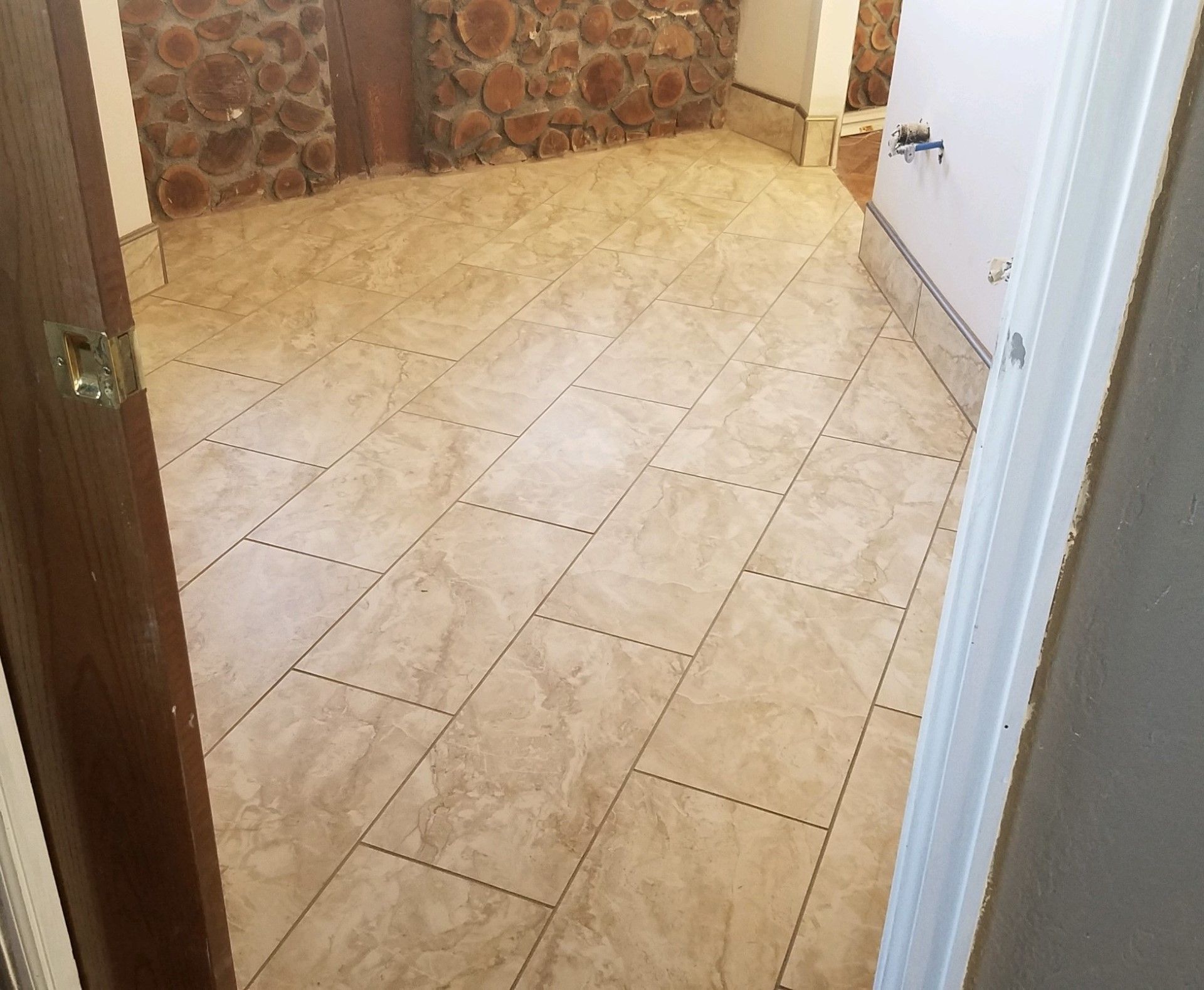 A room with a tiled floor and a stone wall.