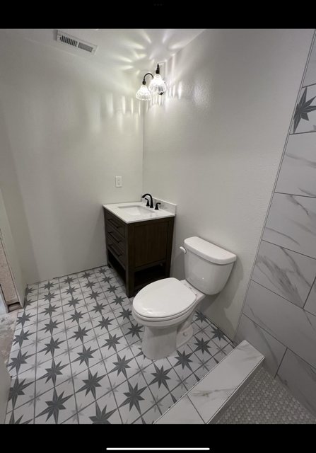 a bathroom with a toilet , sink and shower .