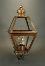 Copper-framed hexagonal lantern with clear glass panels, a bulb inside, and an ornate bracket.