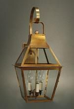Brass outdoor wall lantern with glass panels and three light bulbs.