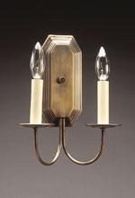 Brass wall sconce with two candle-shaped bulbs on a dark background.