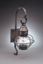 Metal wall lantern with a clear glass globe and arched arm, emitting soft light.