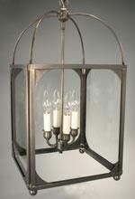 Lantern-style pendant light fixture with four candle-shaped bulbs in a metal frame with glass panels.