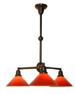 Three-light pendant lamp with orange cone-shaped shades and dark metal frame.