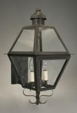 Black hexagonal outdoor wall lantern with glass panels and two light bulbs.