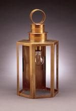 Brass outdoor wall lantern with a hexagonal frame and a lightbulb inside.