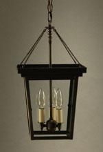 Black lantern pendant light with clear glass panels, two candle-shaped bulbs, hanging from a chain.