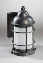 Dark metal wall-mounted outdoor light fixture with a cylindrical, frosted glass shade, and cage-like bars.
