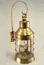 Brass wall-mounted lantern with clear glass panels, cylindrical shape, and curved arm.