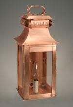 Copper lantern with clear glass panels, an arched handle, and an exposed lightbulb.