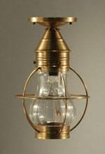 Brass and glass ceiling light fixture with a caged bulb, set against a neutral background.