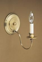 Brass wall sconce with a candle-shaped lightbulb, on a beige wall.