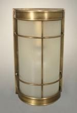 Brass-framed wall sconce with a frosted glass cylinder and curved top and bottom edges.