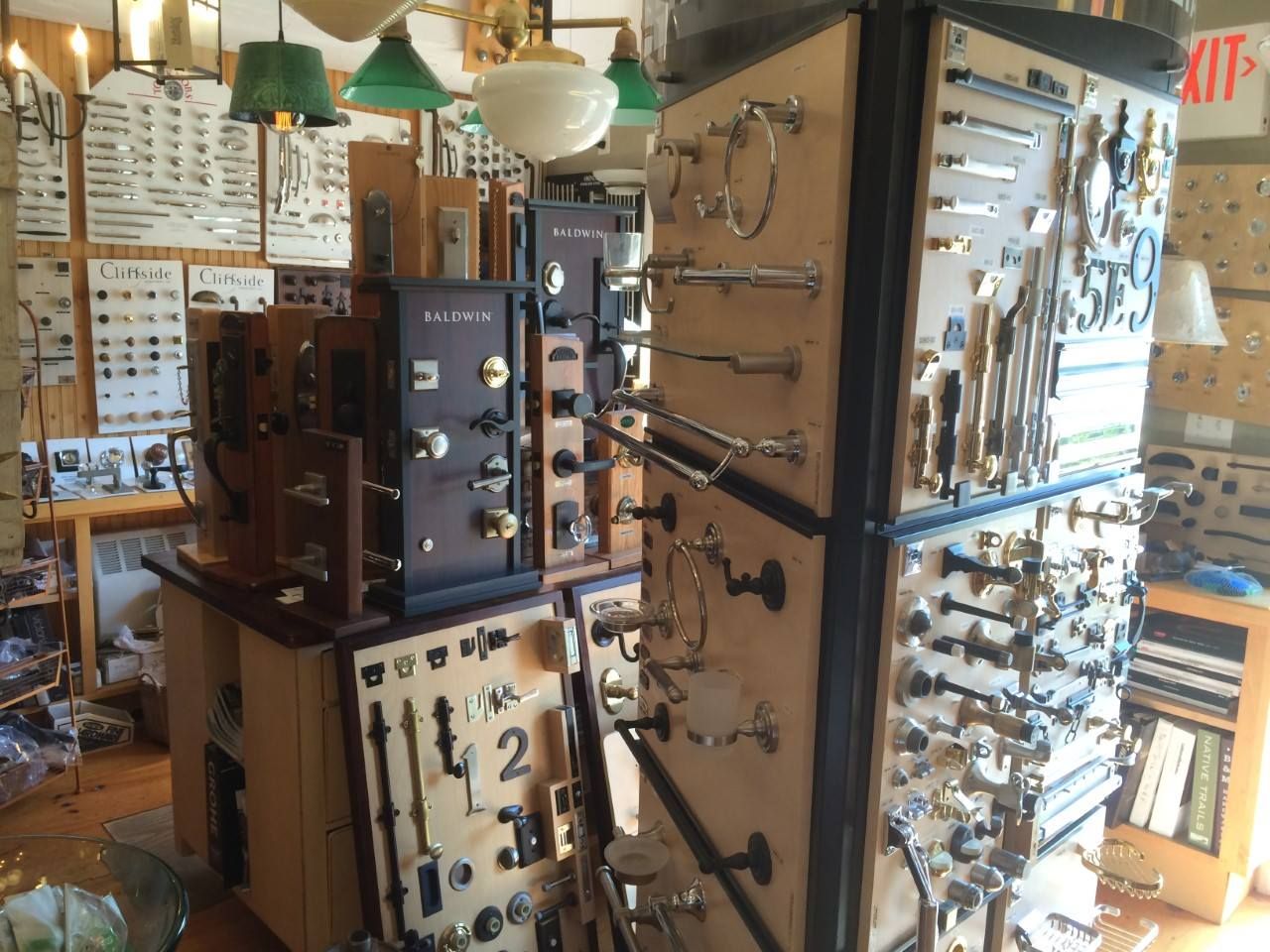 Display of hardware, including doorknobs and handles, in a store with various lighting fixtures.